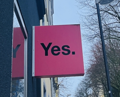 YES in schwarzen Lettern auf Pink